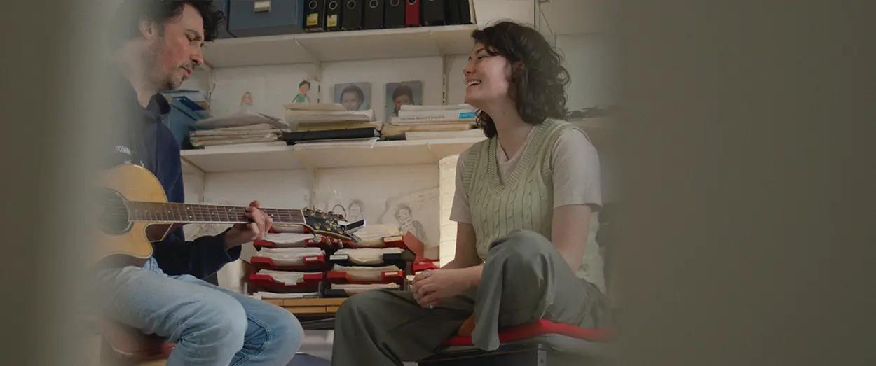 Girl and her dad playing guitar together