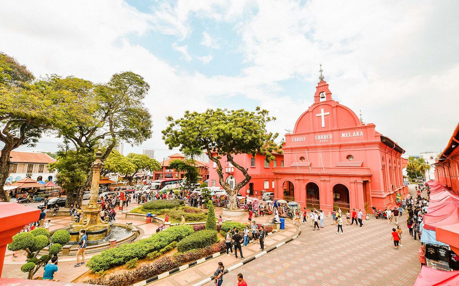 Christ Church Melaka with tourists exploring the historical site on a Melaka tour from Kuala Lumpur.