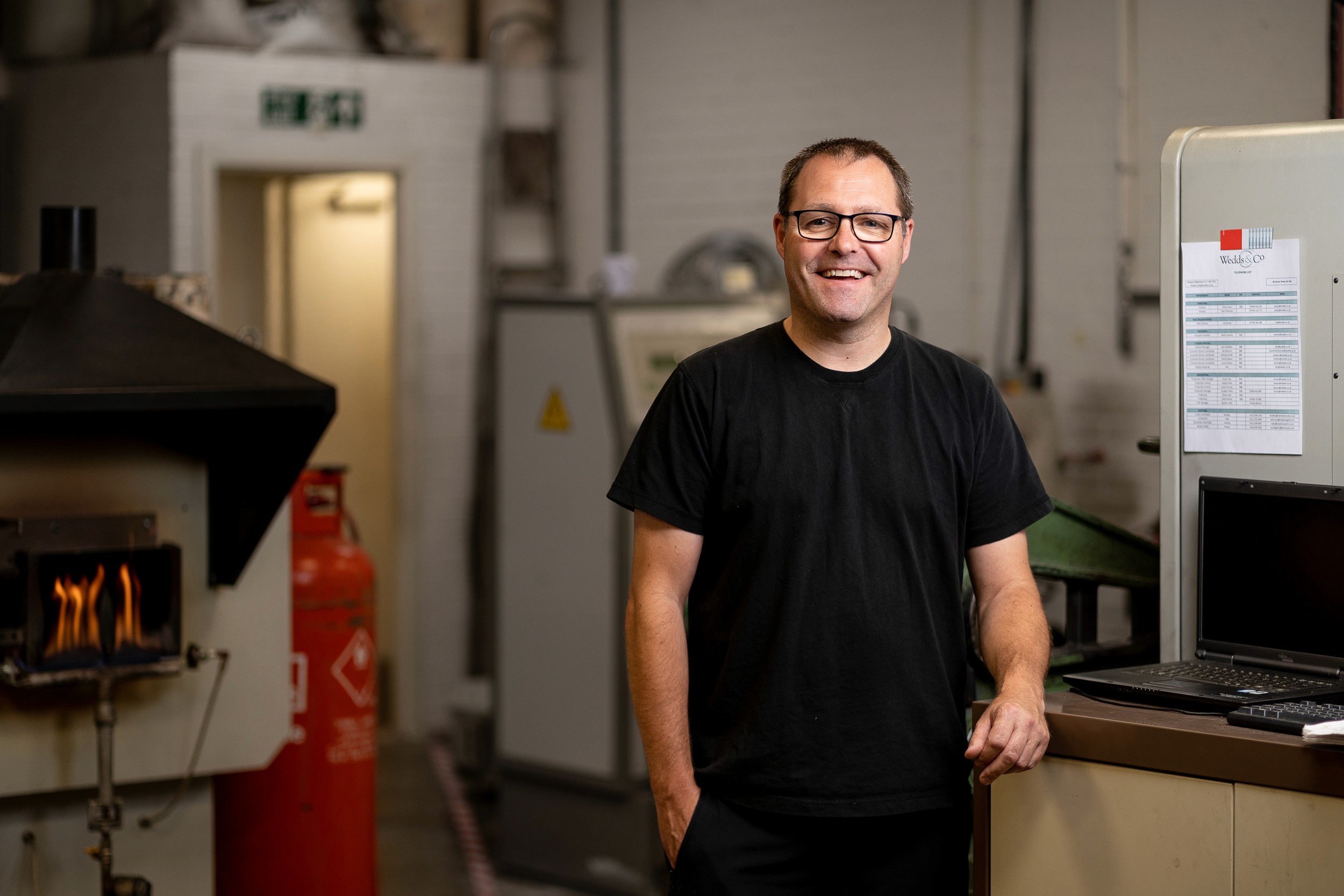 jeweller standing next to metal working machines