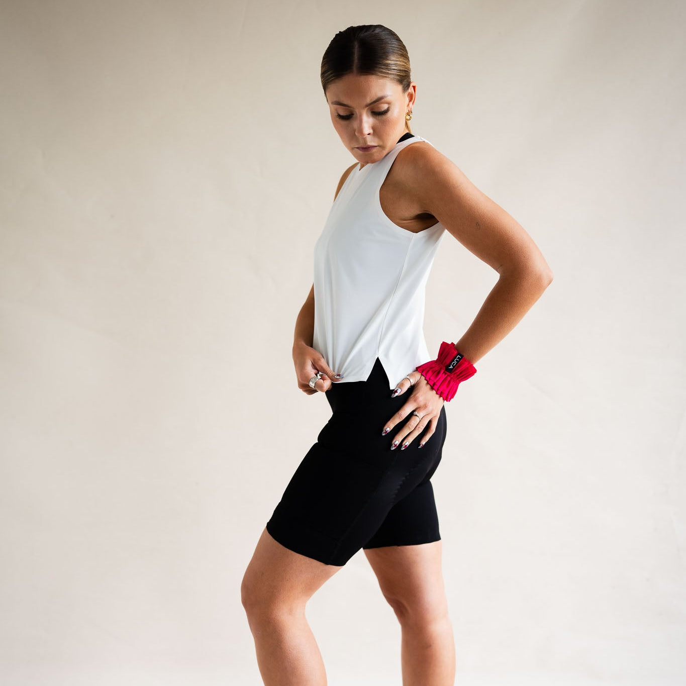 Cyclist wearing LUCA Meander vest in white with cycling shorts, three-quarter view