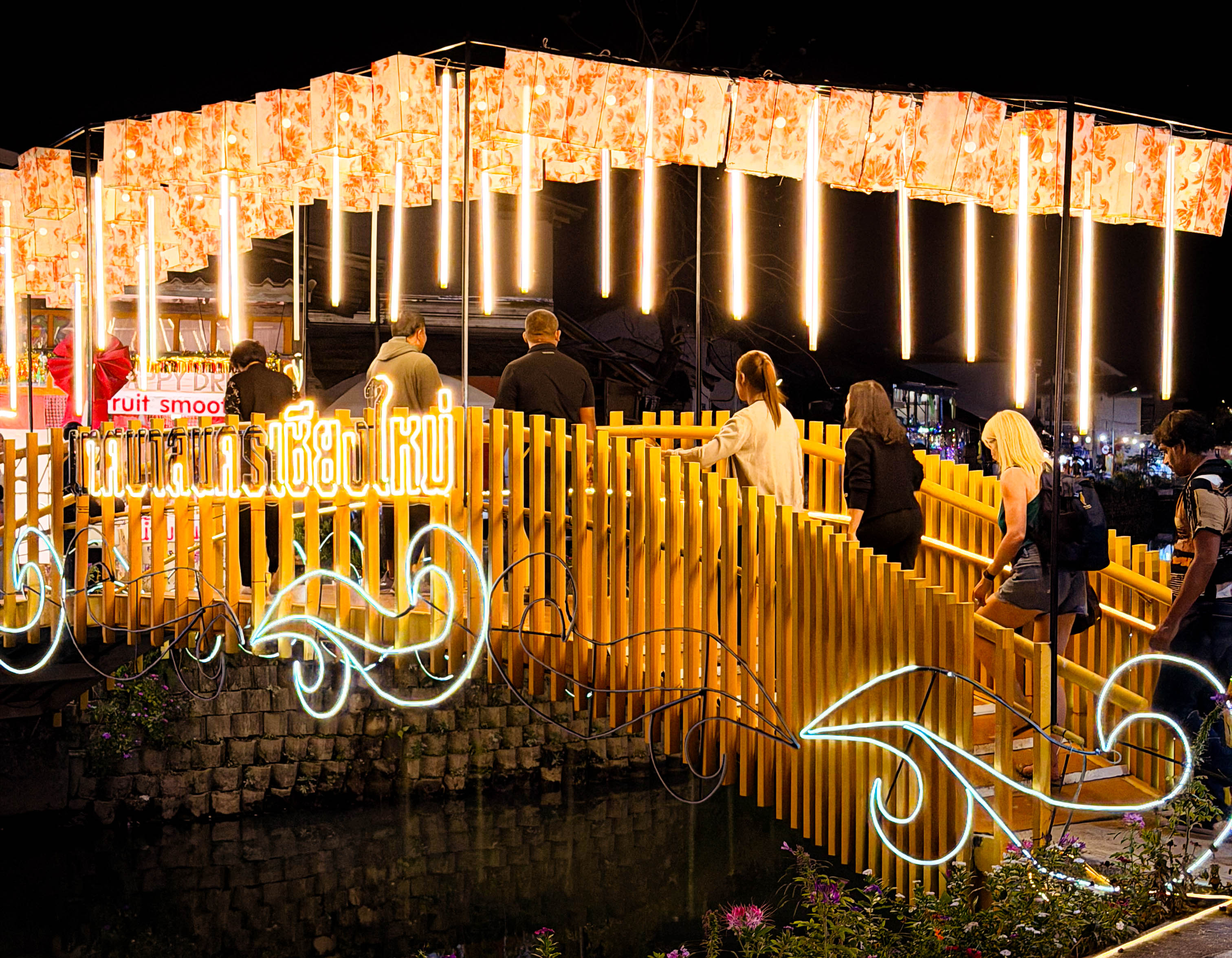a yellow walking bridge decorated with latterns and lights