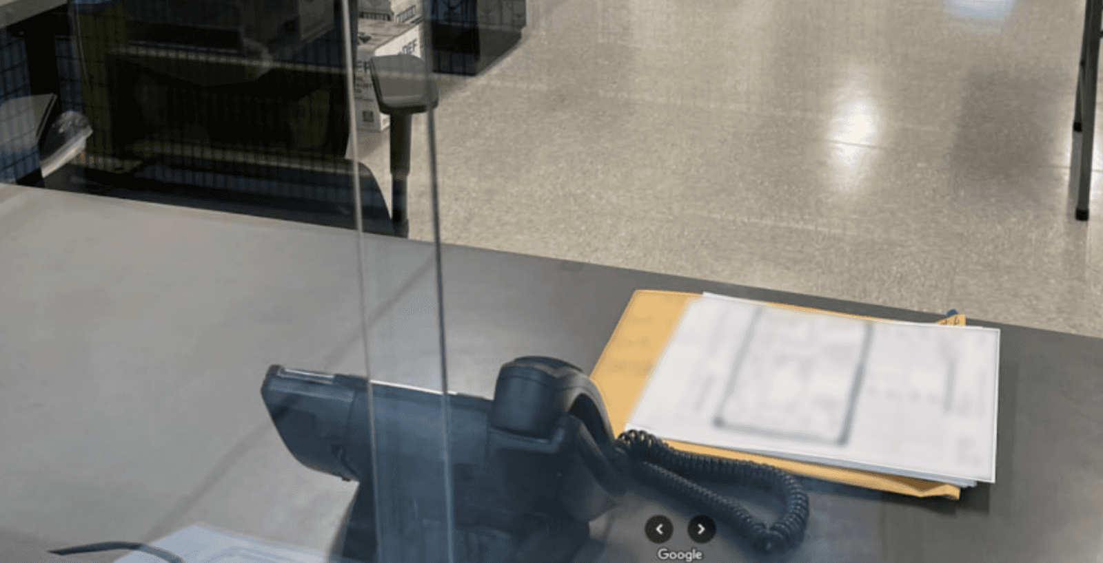 Image of a front desk's phone and private documents out in the open.