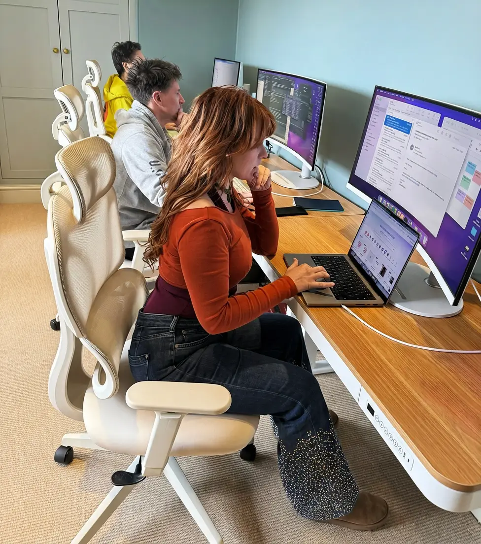 Froomies residents working at large monitors in the co-working space