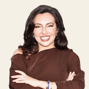 Headshot of Maryam Salehijam, smiling with arms crossed in a brown off-shoulder top.