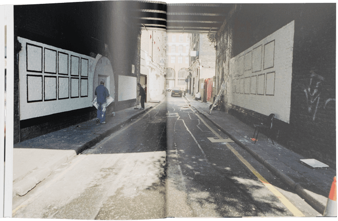 Open book showing two street scenes with pedestrians and urban elements.