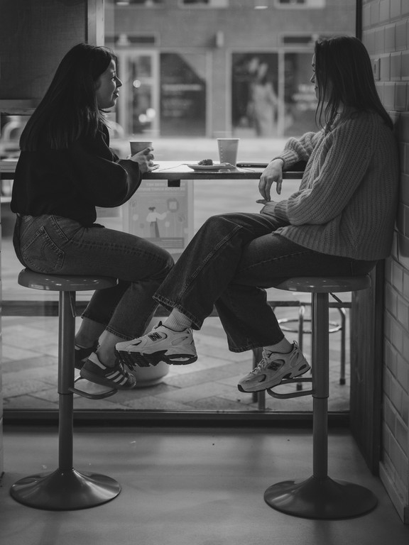 Two women talking at a cafe table