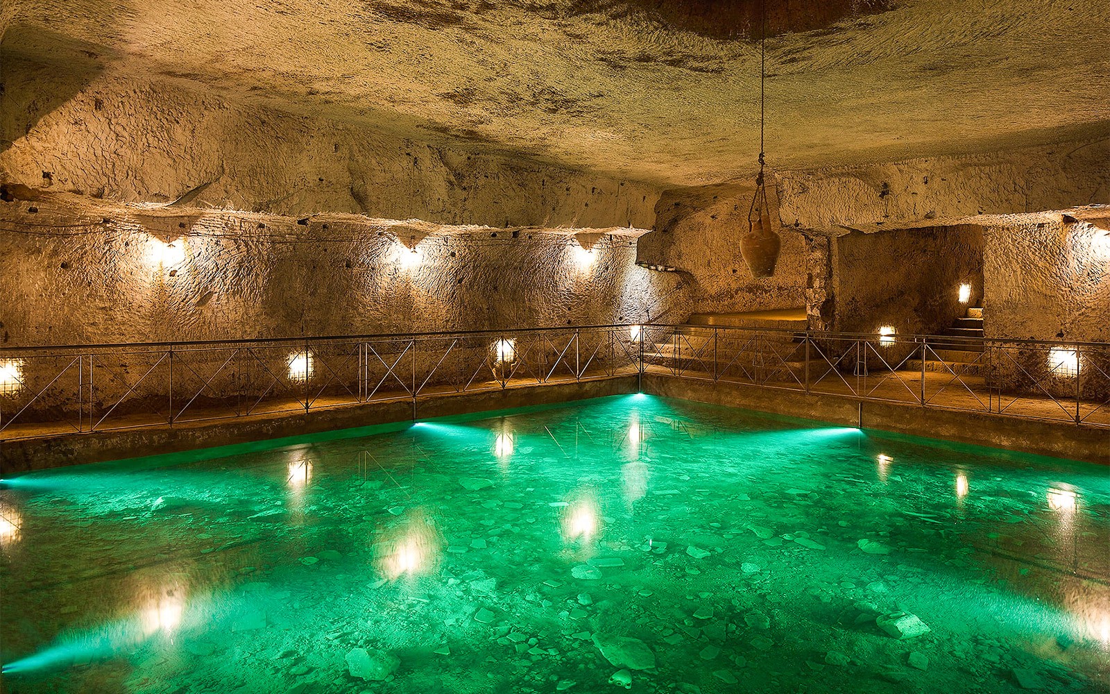 Rondleiding door de Bourbon Tunnel met verlichte ondergrondse poel en stenen muren.