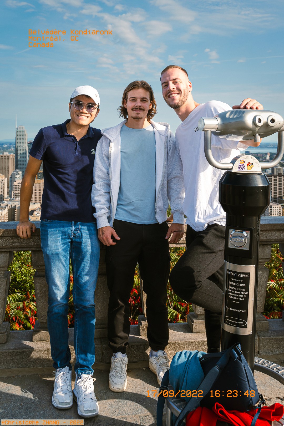 Trois amis posent devant la skyline de Montréal au Belvédère Kondiaronk.