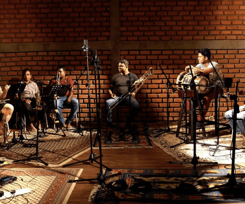 A man playing a drum in front of a group of people