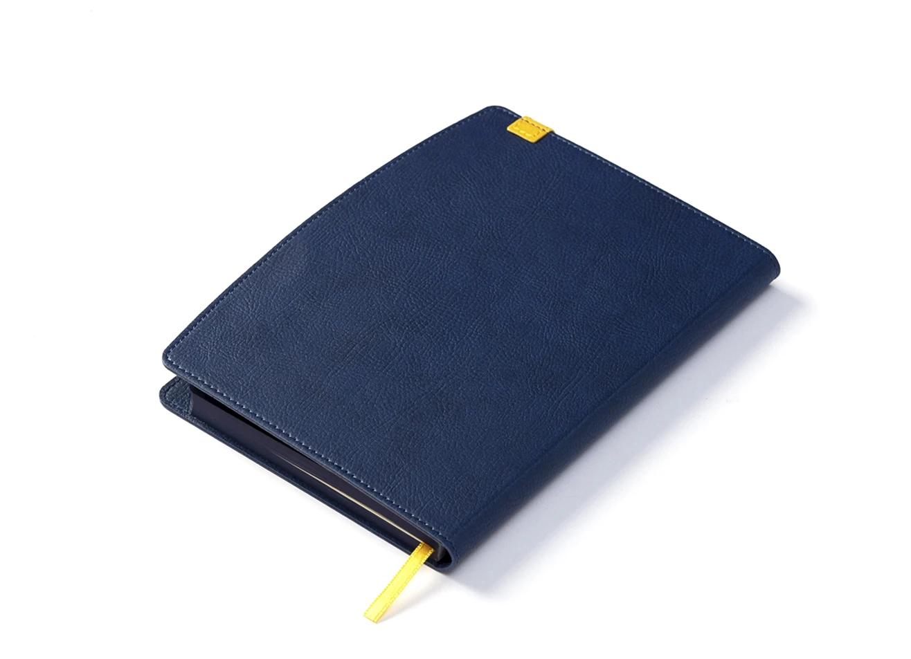 Back angled view of blue notebook with yellow ribbon bookmark.