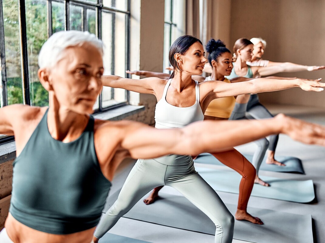 mixed group of women doing weight loss with yoga in a well-lit studio