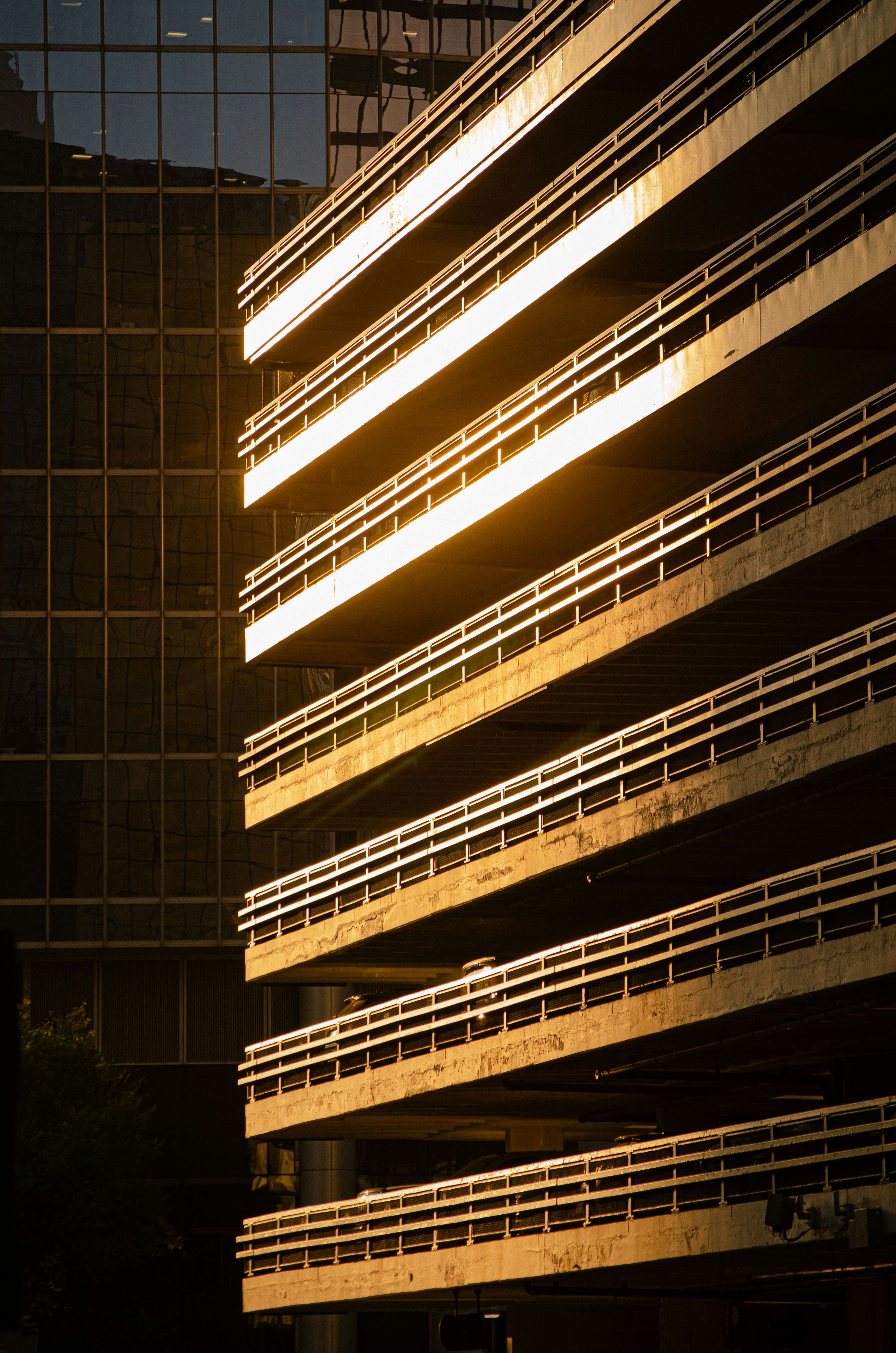Sunlight illuminates a concrete parking garage structure.