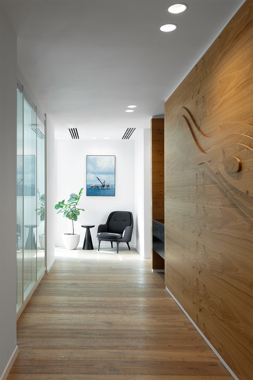 דלפק קבלה מעוצב עם אלמנט מיתוג ייחודי על רקע קיר אבן – עיצוב קונספטואלי למשרדים