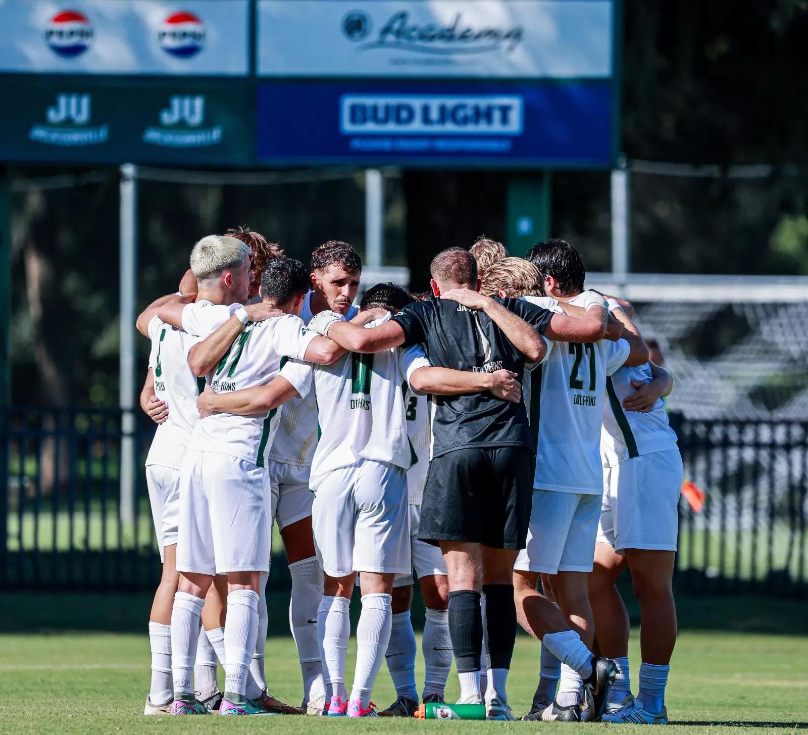 man in blue and orange jersey shirt running on green grass field during daytime
