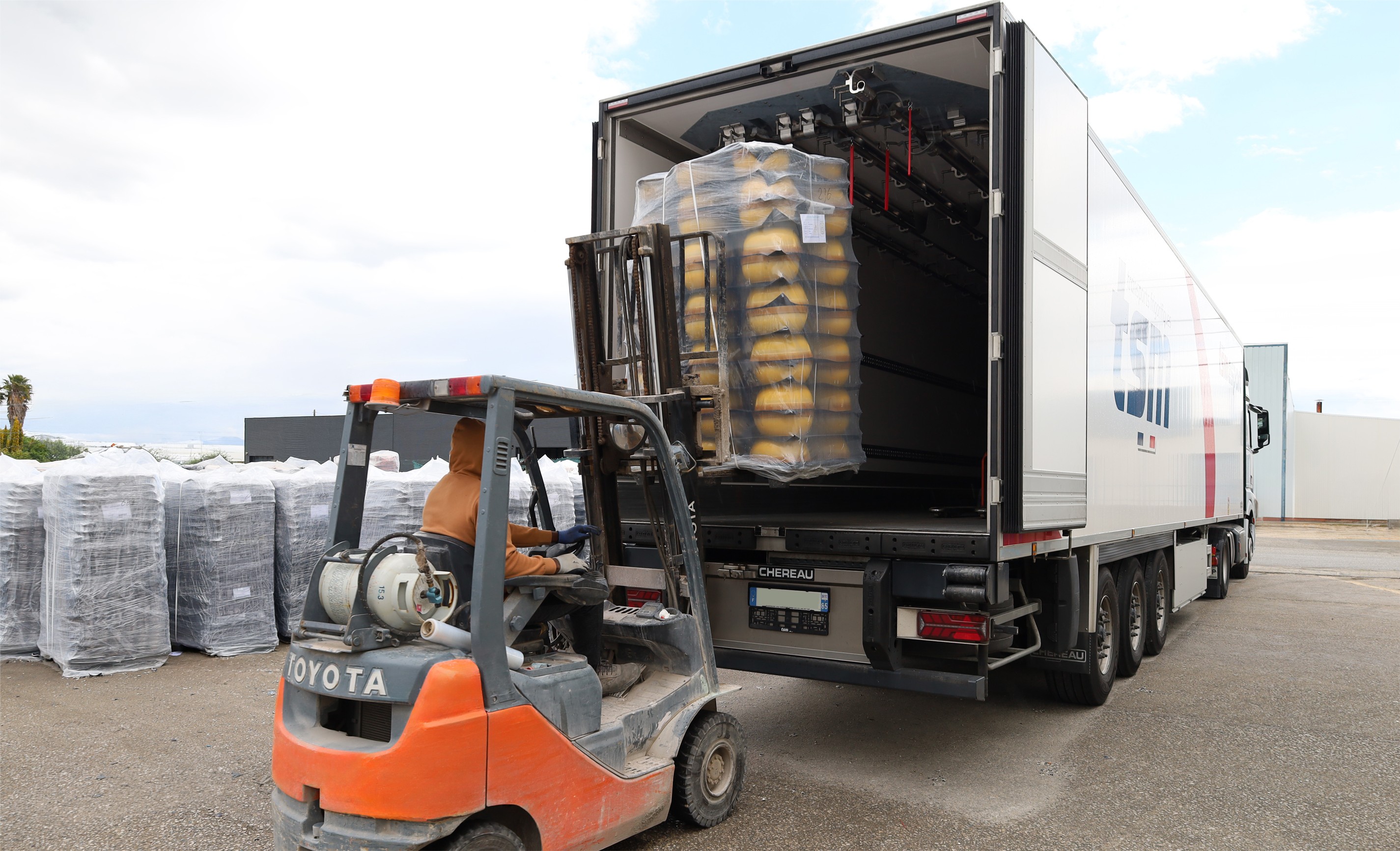 Chargement d'une palette de pièces en céramique emballées dans un camion à l'aide d'un chariot élévateur Toyota, en extérieur