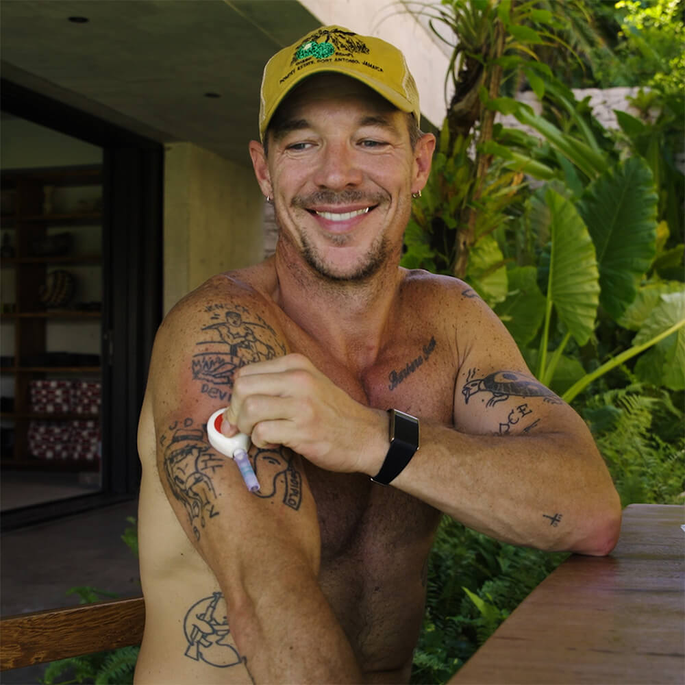 Diplo doing the rythm health at home blood test smiling.