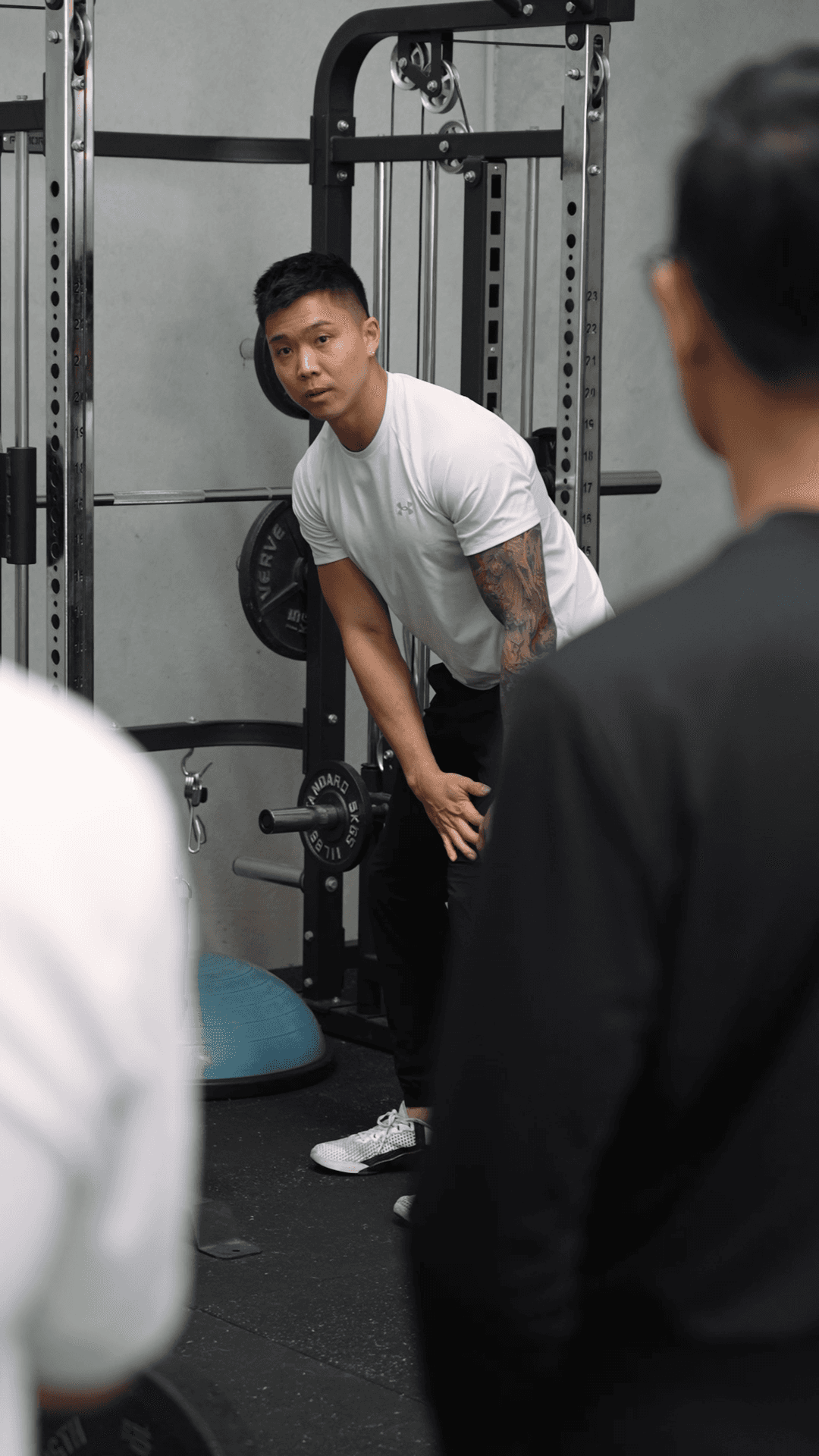 man in black t-shirt carrying barbell