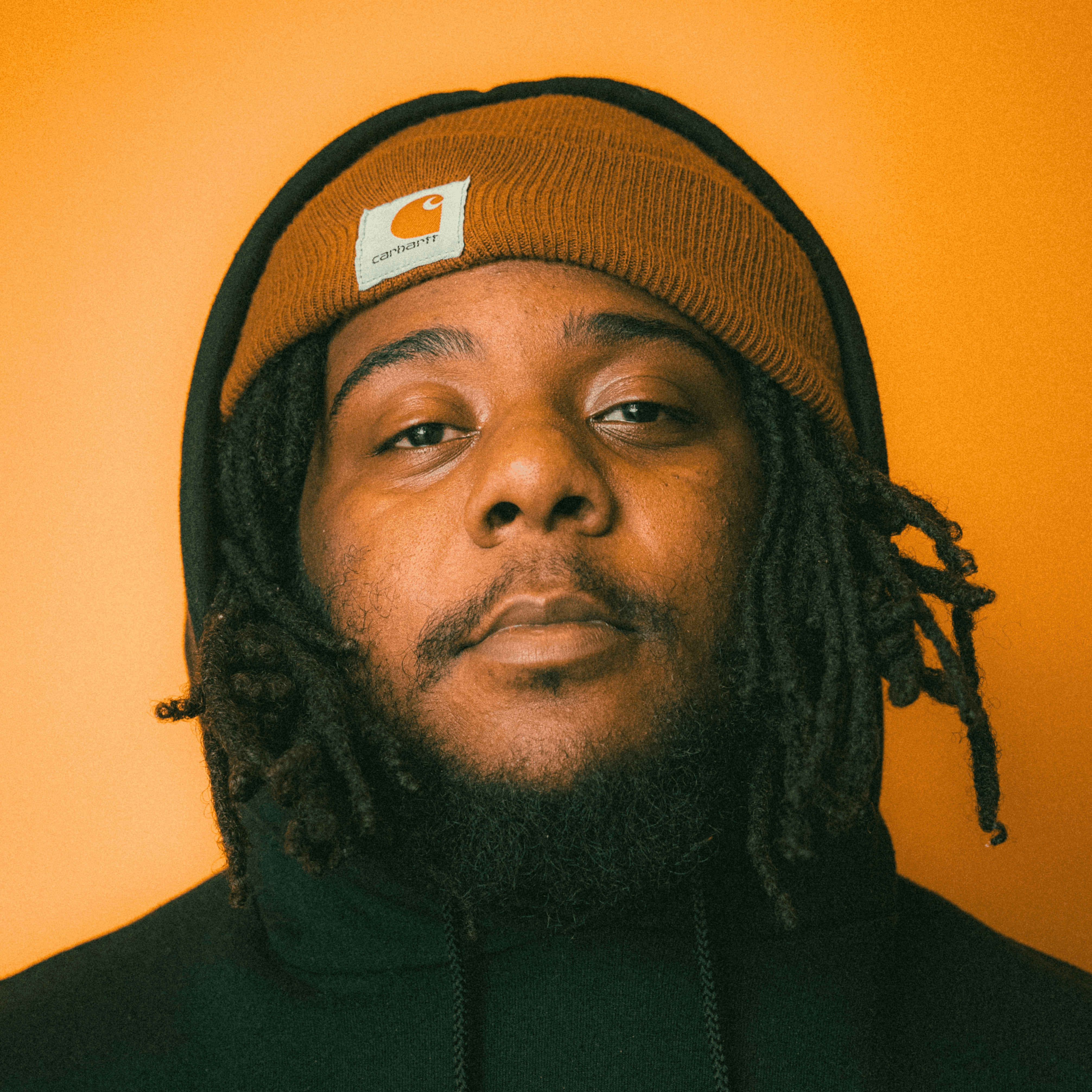 a man with dreadlocks wearing a black hoodie