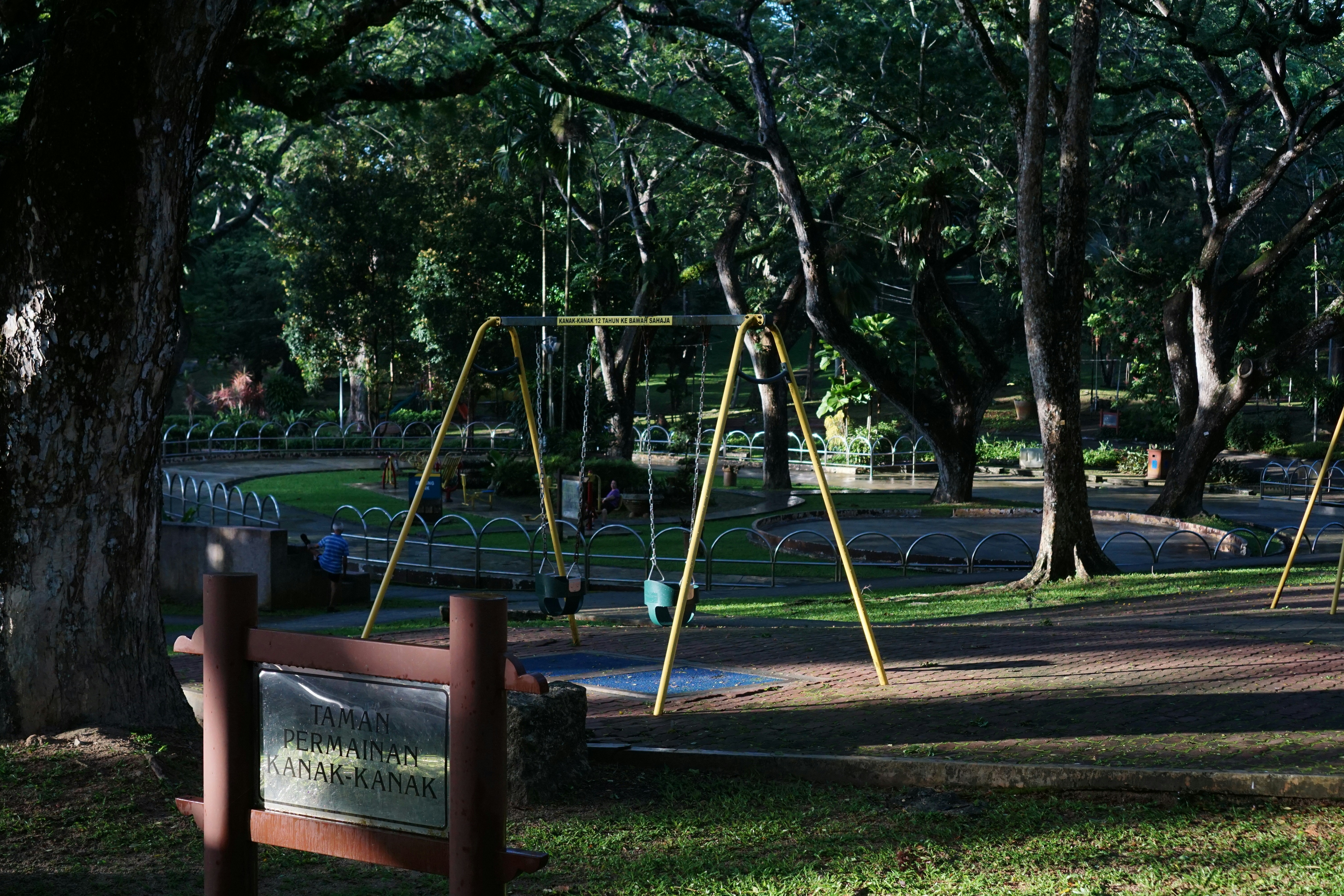 A playground with swings in a park.