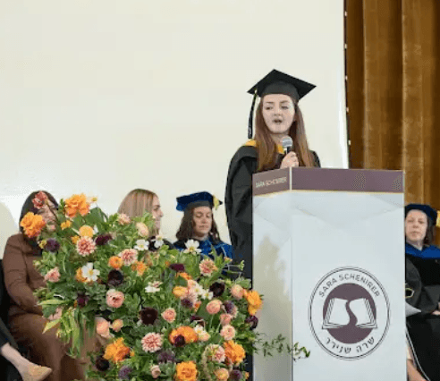 woman wearing blue denim jacket holding book