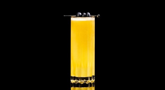 A closeup of a Wings of Passion Fruit drink against a dark background.