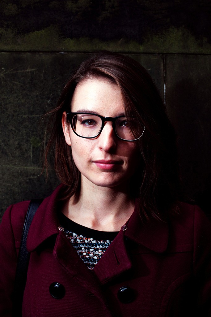 Gosia – Bitter Sweet – intense close-up resting her chin on an orange placed on her knee