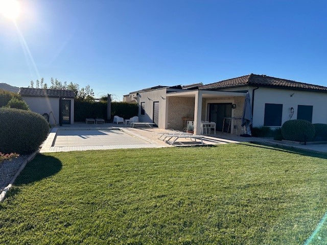 Maison moderne avec piscine et jardin ensoleillé, extérieure d'une propriété de luxe