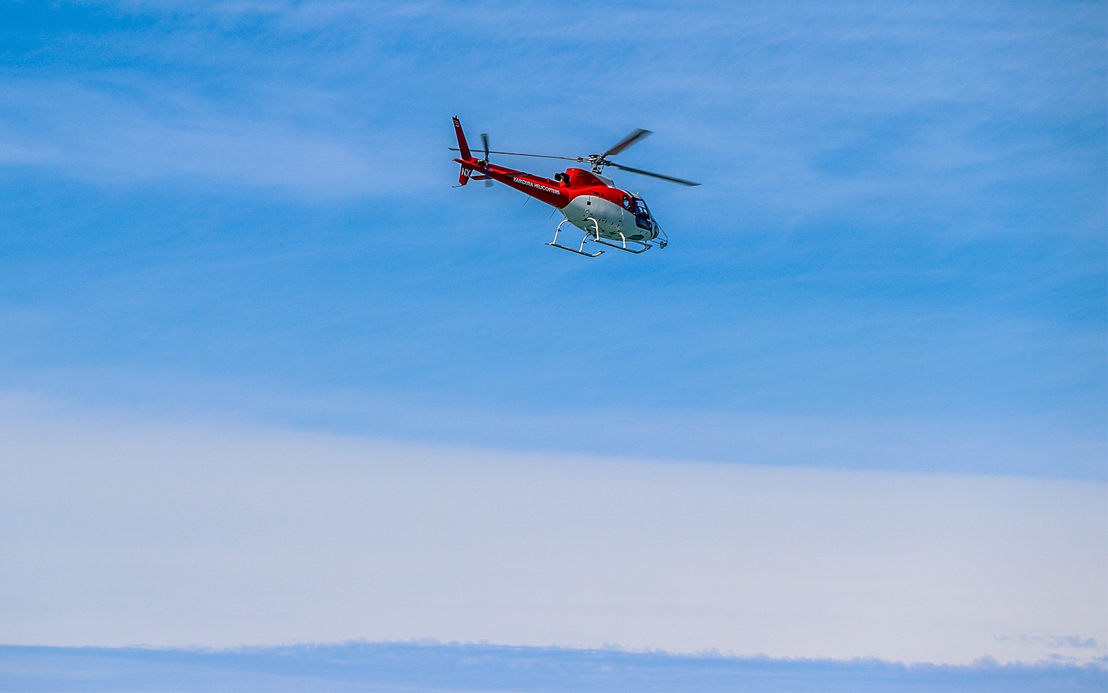 Hubschrauberflug über Kaikoura, Neuseeland, vor einem klaren blauen Himmel.