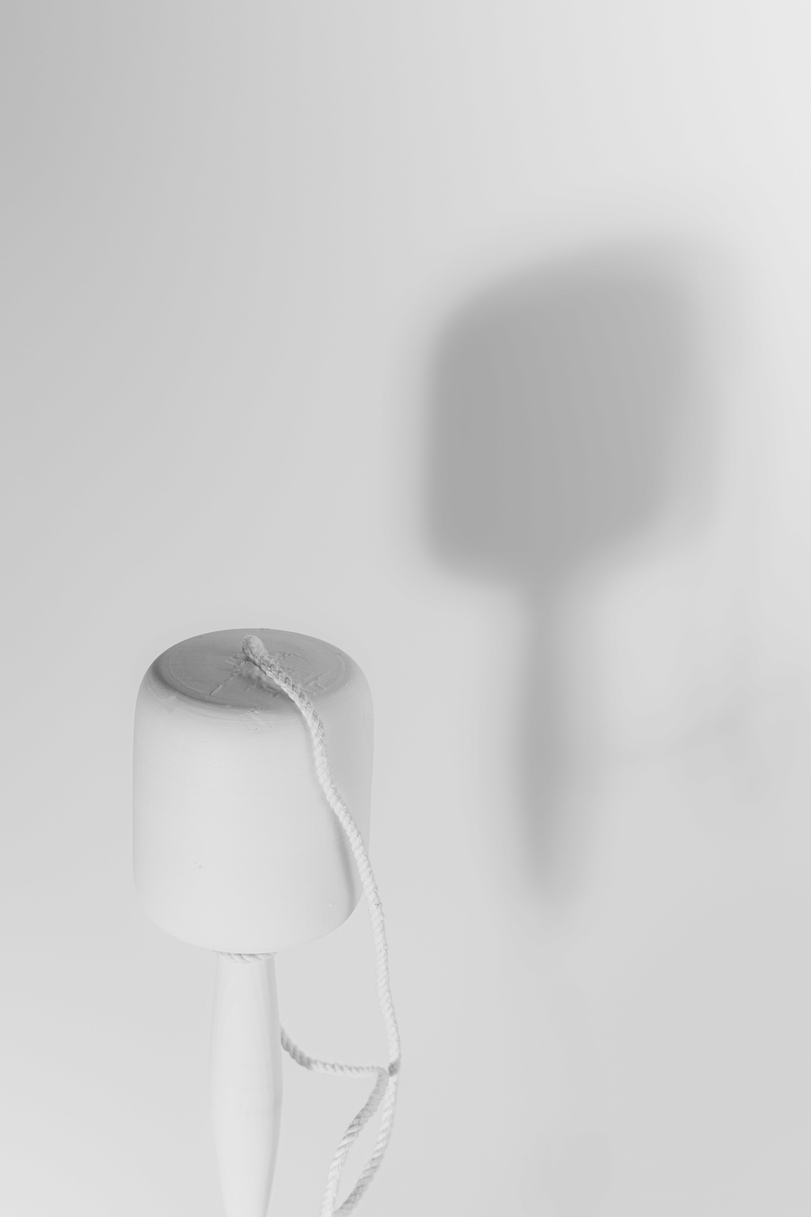 Photograph of a traditional wooden balero toy casting a soft shadow on a light background.