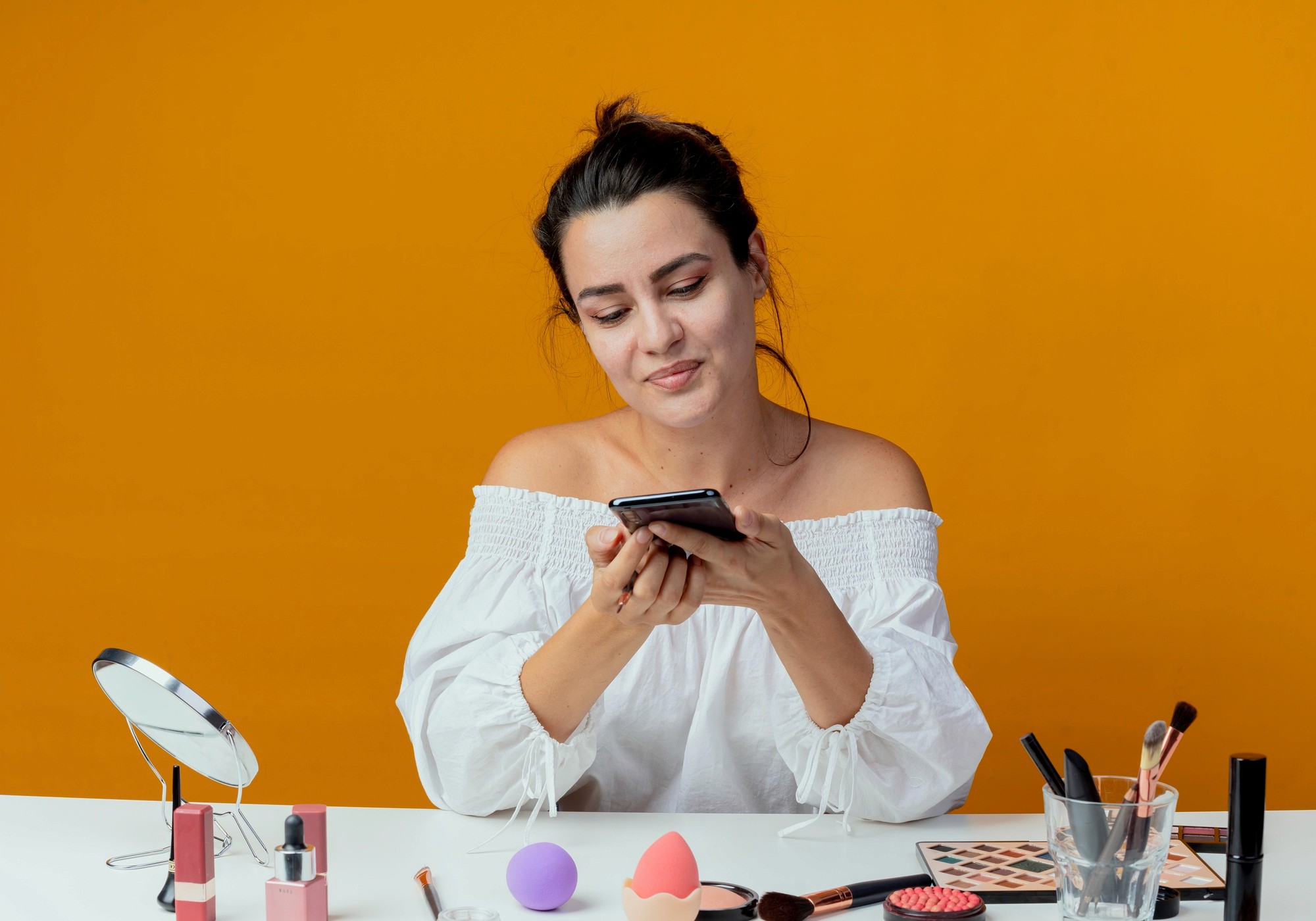 A makeup artist using a smartphone to verify product details mapped from Shopify into the Consult Beauté system.