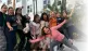 Grupo de personas riendo y celebrando juntas al aire libre, transmitiendo alegría, amistad y energía positiva frente a un edificio moderno.