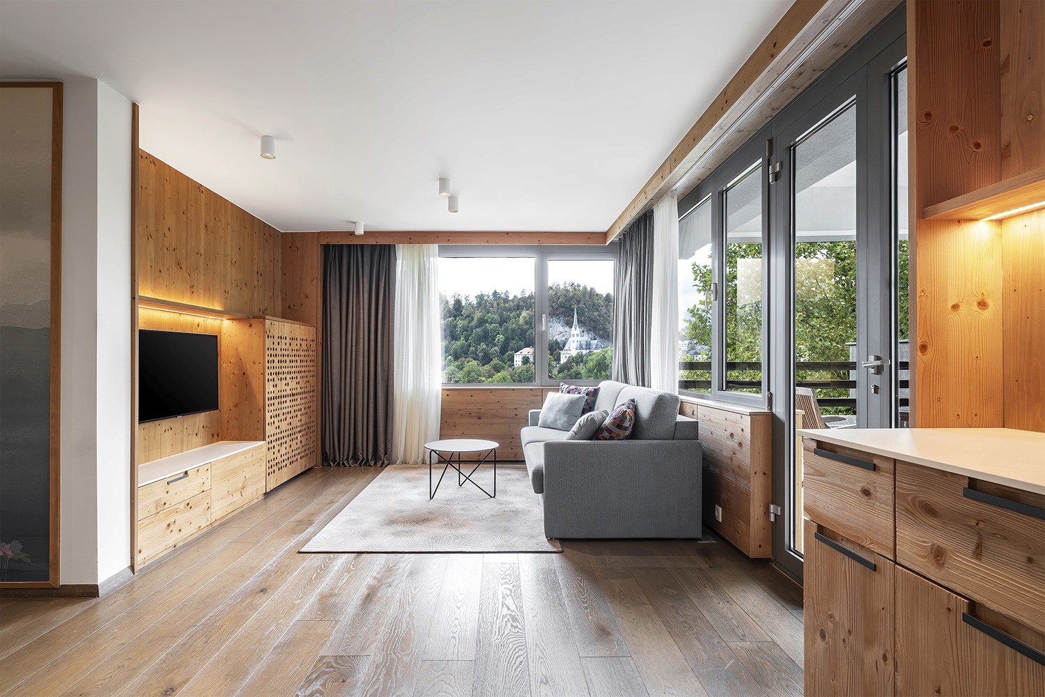 Modern hotel apartment interior at Hotel Park Bled with natural light and wooden finishes.