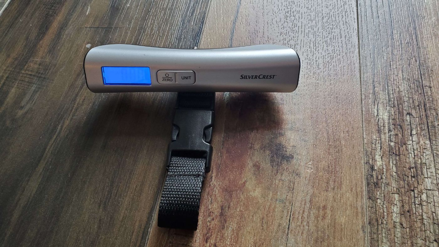 Pèse-bagages numérique SilverCrest avec écran LCD bleu et sangle noire, sur plancher en bois à Montréal Plateau