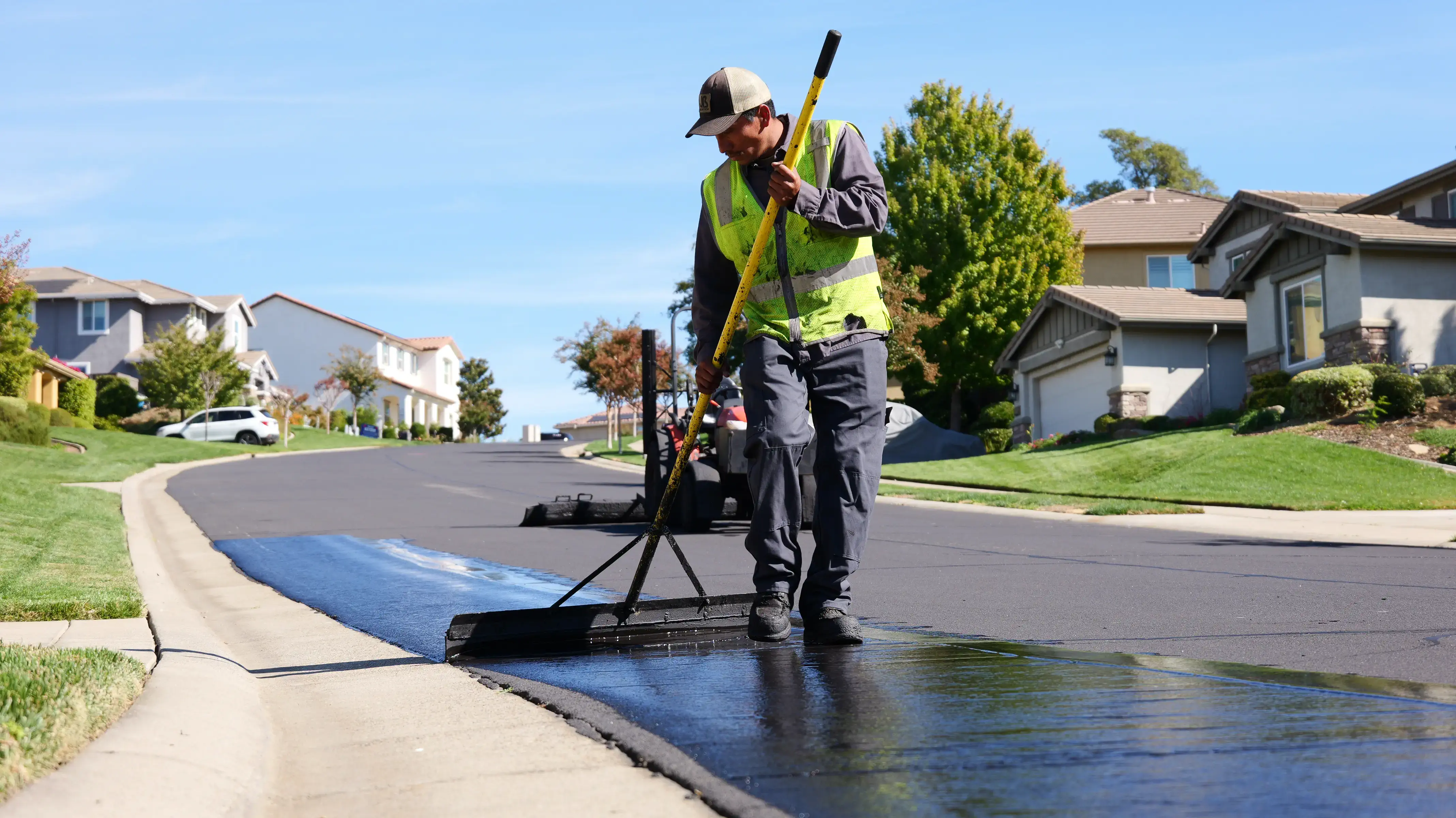 Sealcoat crew applying seal coating with hand squeegee