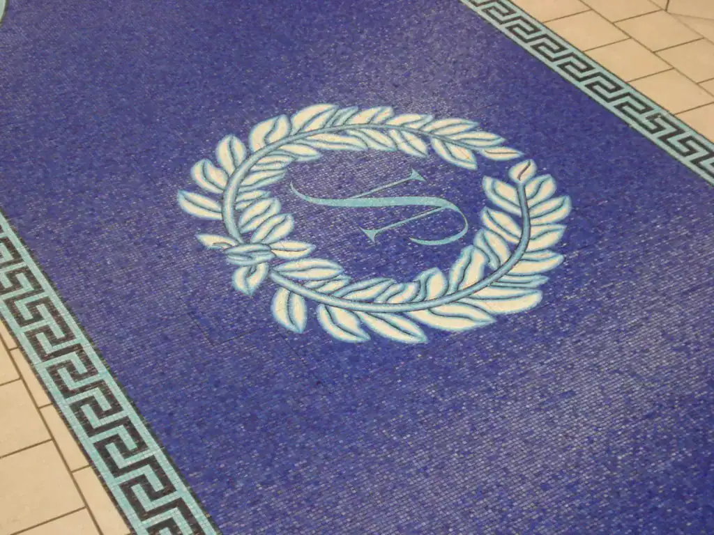 Monogram mosaic medallion with a laurel wreath and Greek Key border, laid out in the studio before shipping.