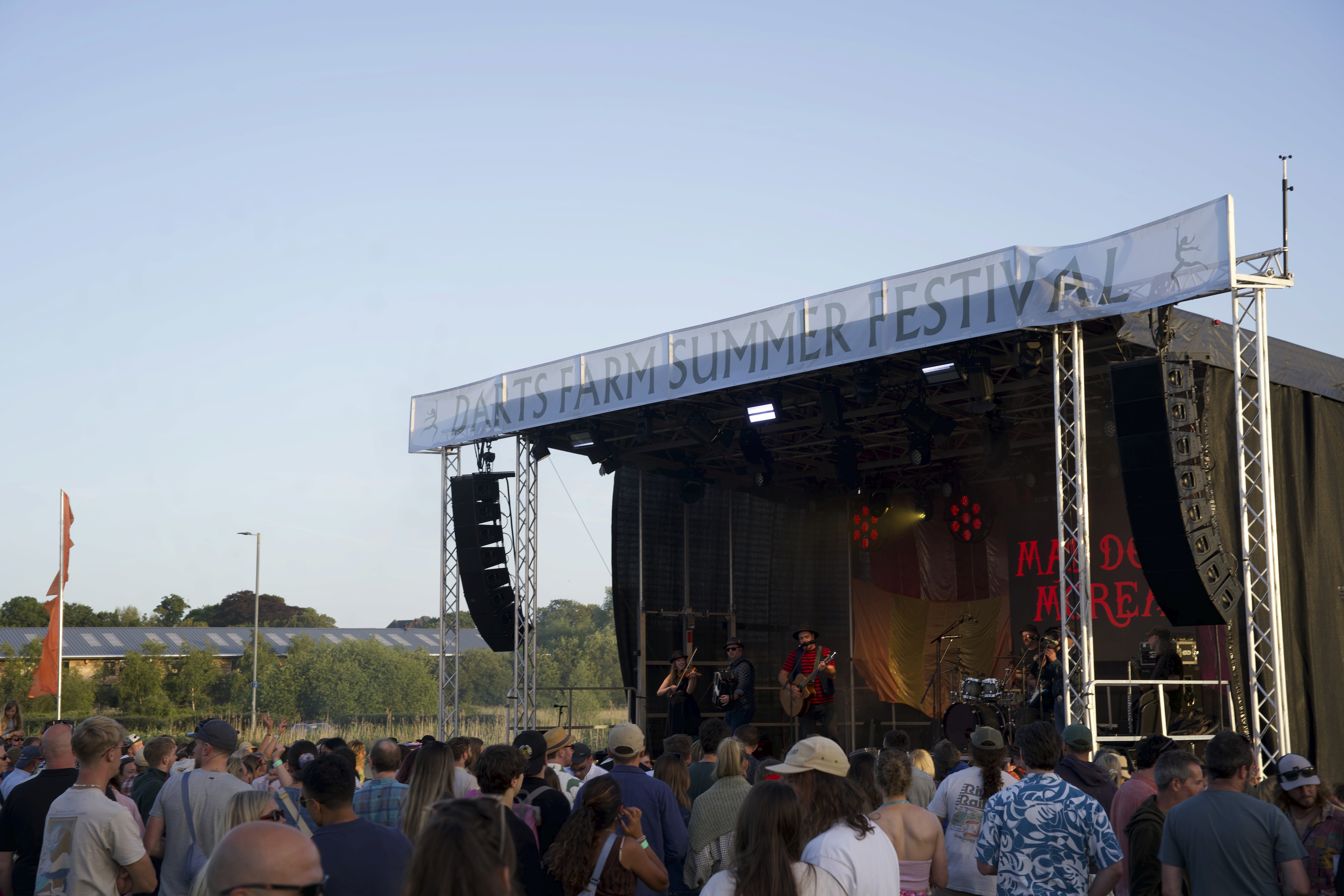 Crowd watching a live band perform on the main stage at Darts Farm Summer Festival.