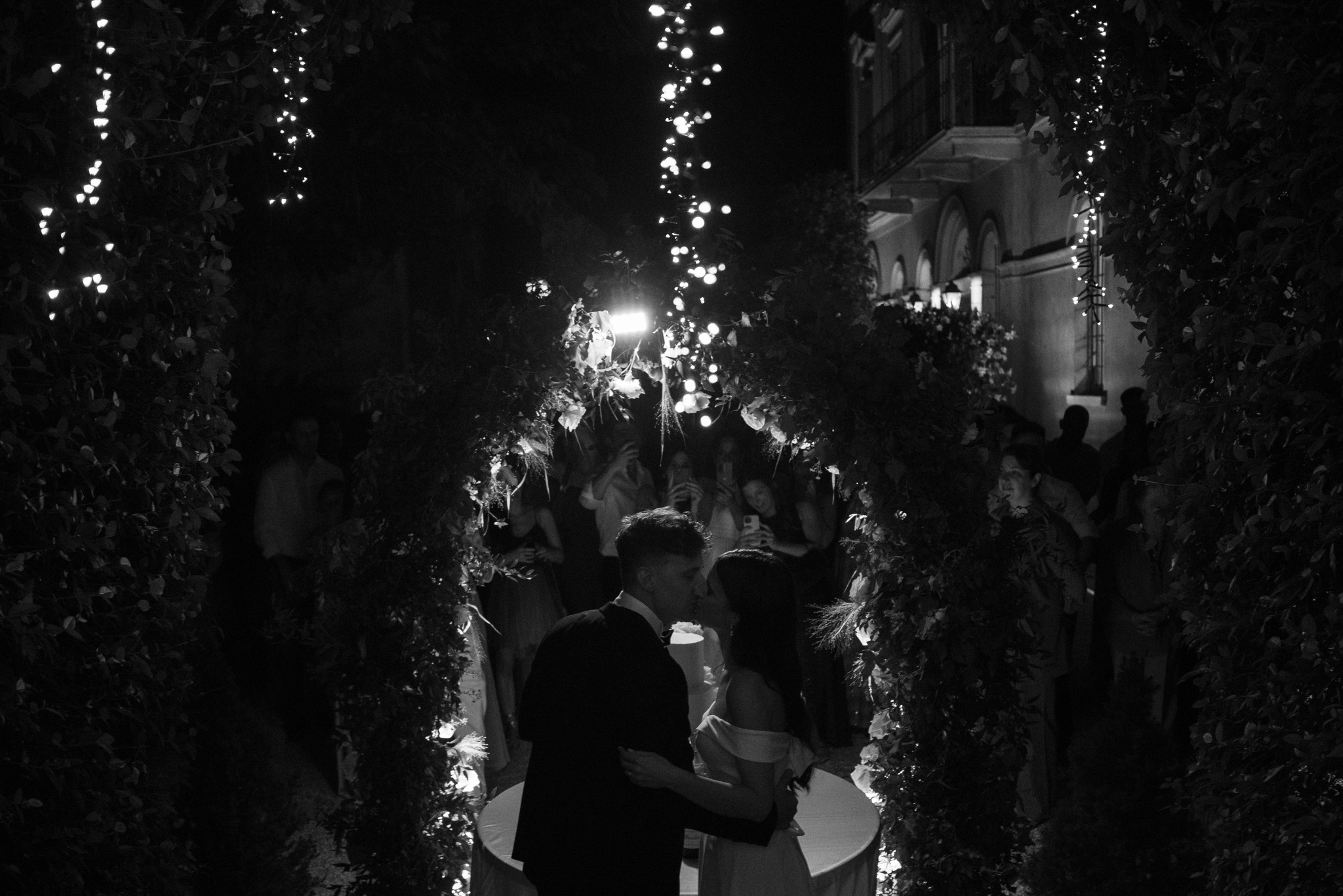 Sposi camminano tra corridoi illuminati di luci bianche, reportage matrimoniale a Villa Negri, atmosfera notturna elegante