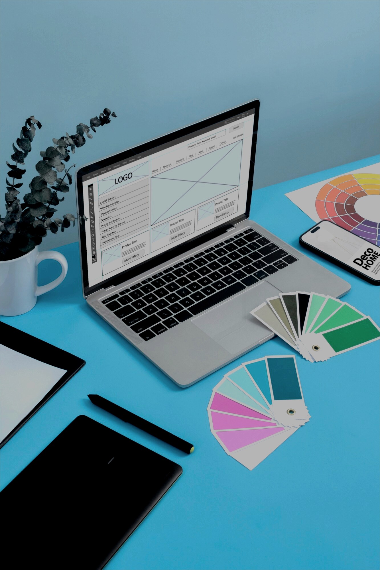 a flat lay of a smartphone, stylus, and fan of color swatches on a bright blue desk.