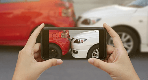 car accident scene being photographed with smart phone