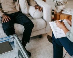 A woman writing while a man is sitting