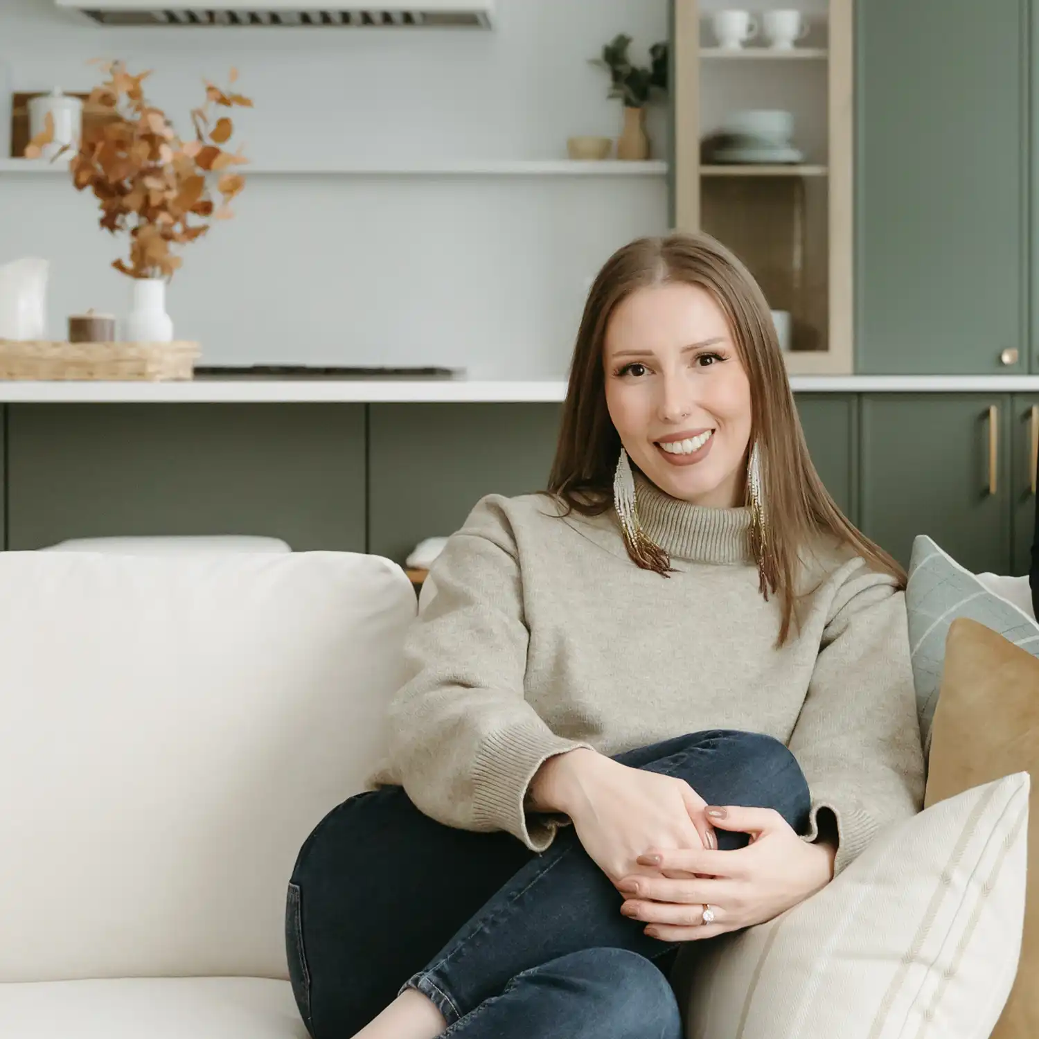 Kayla Nixon, principal interior designer and founder of The Simone Co., seated on a patterned rug with design swatches, material samples, and a laptop in a styled living space
