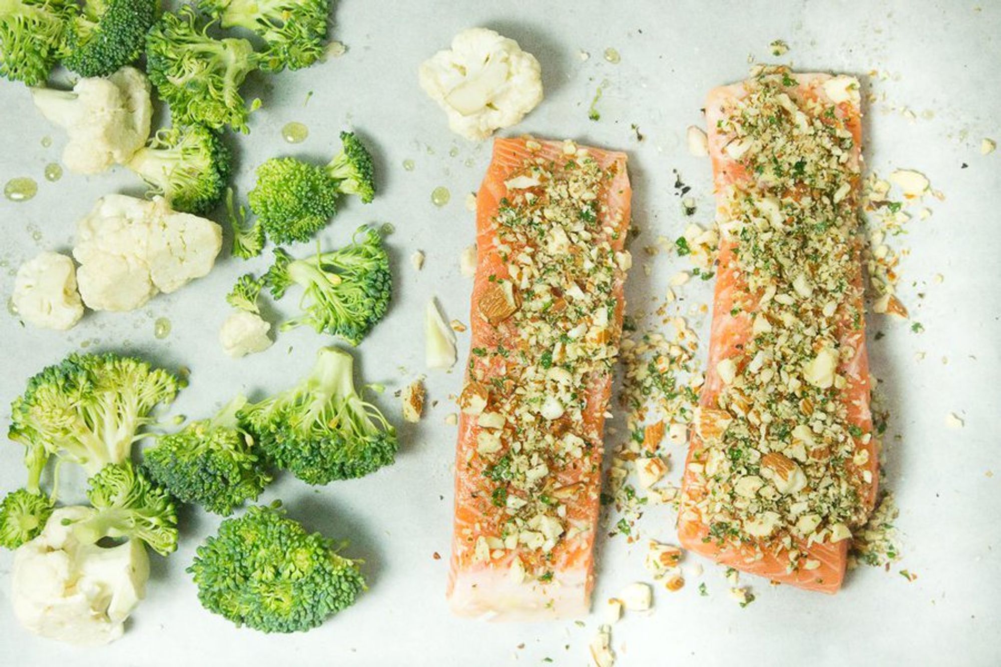 veggies and salmon filet laid on a baking sheet