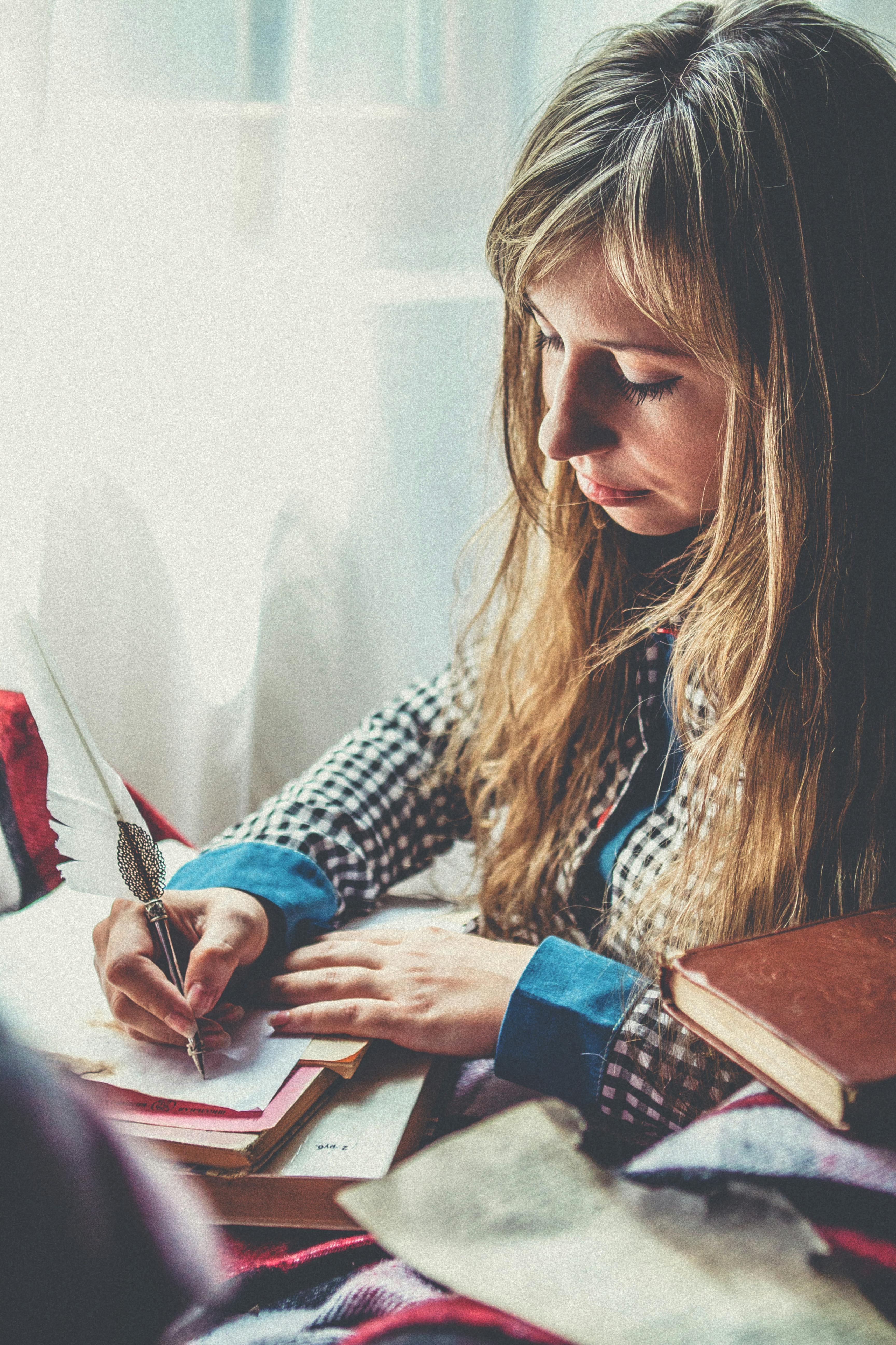 Photo of a Woman Writing on Paper
