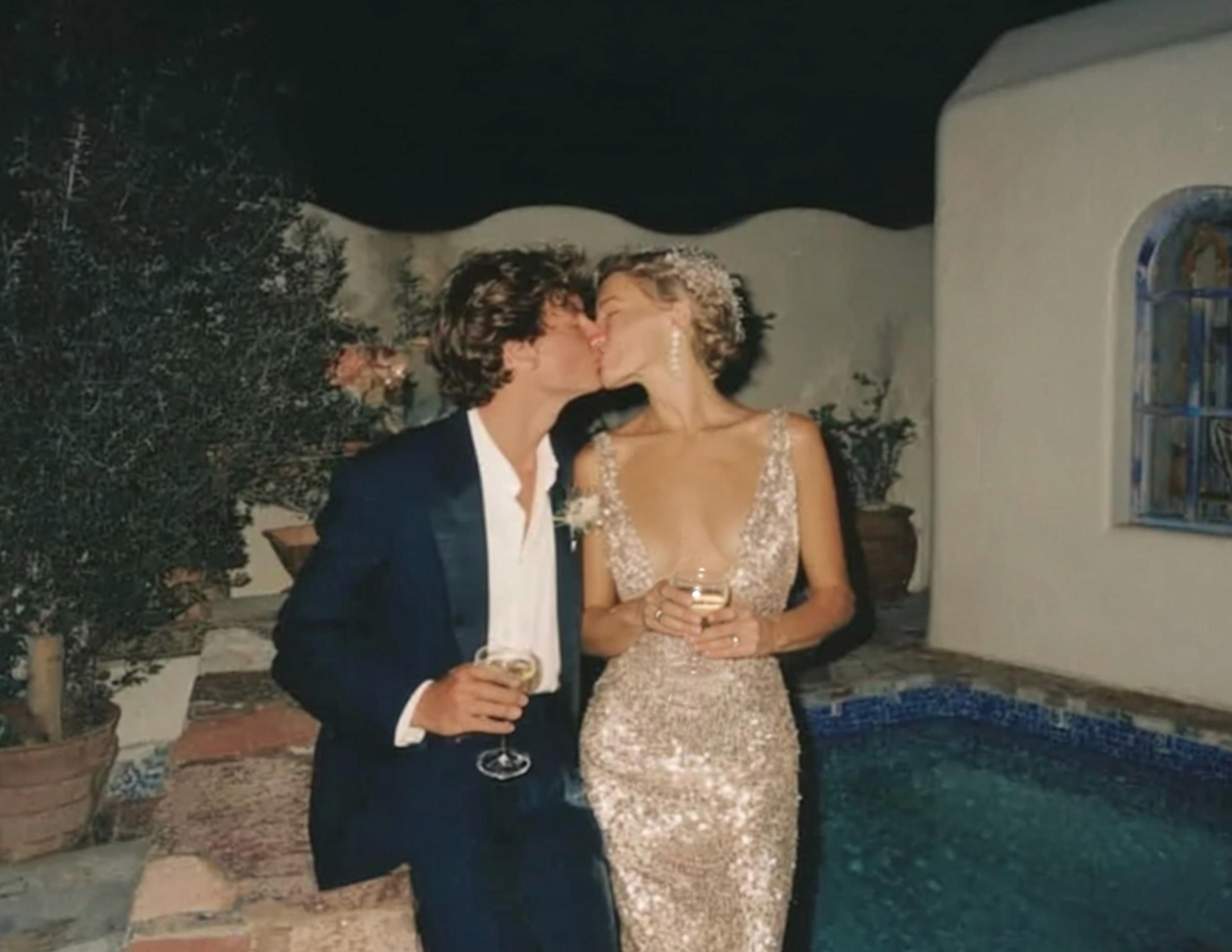 candid wedding photo of couple kissing by pool