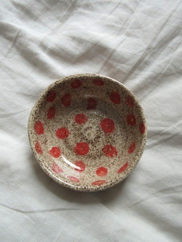 Speckled cream ceramic bowl with red polka dots