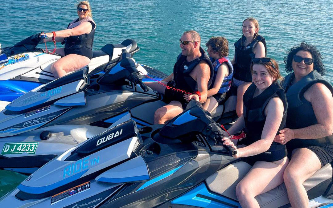 Family and friends preparing for jet skiing in Dubai, wearing safety equipment, demonstrating the importance of safety during water activities with friends and highlighting fun things to do in Dubai in summer