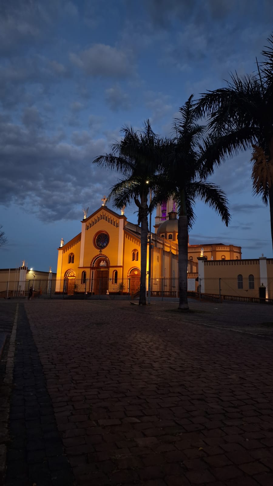 Large crowd enjoying a live concert with stage lights and camera crane filming the event.