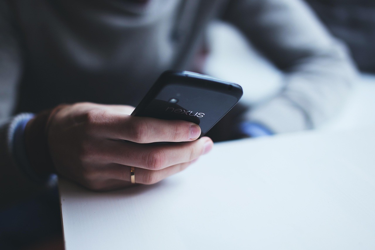 A close-up of a man using his smartphone