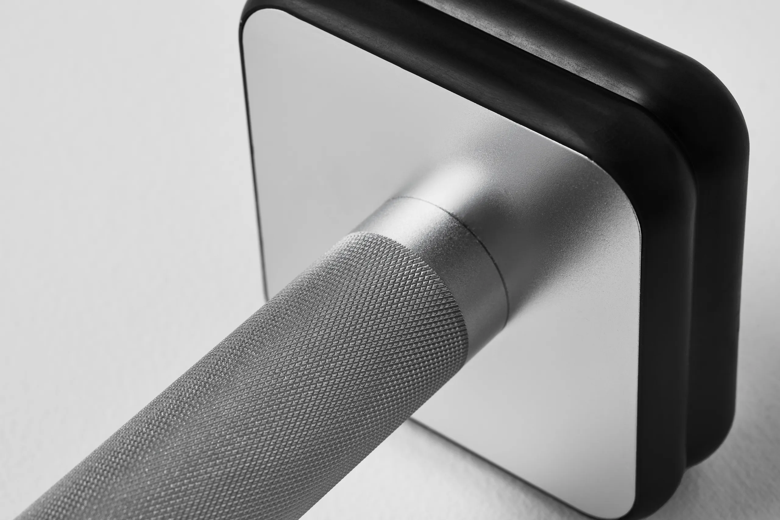 Close-up of the Mirror smart dumbbell showing the textured handle and square connected end