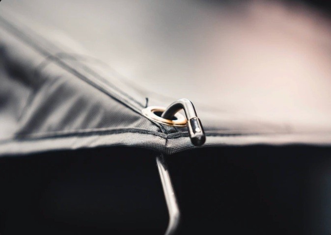 Close-up of a rooftop tent fabric attachment and metal clip